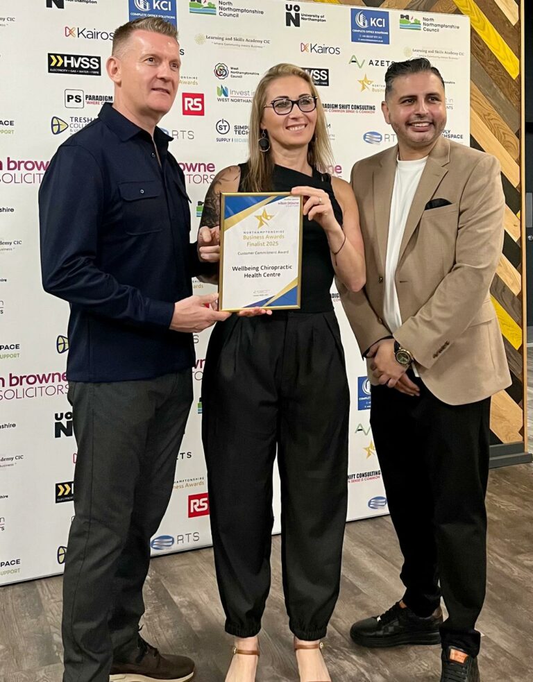 Image of Magda & Dave with Sunny Singh being presented a certificate to show the clinic is one of the finalists of the Northamptonshire Business Awards